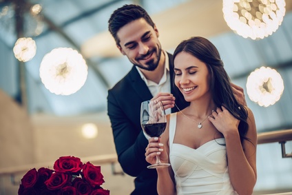 Homme qui offre un collier à sa femme à un dîner romantique